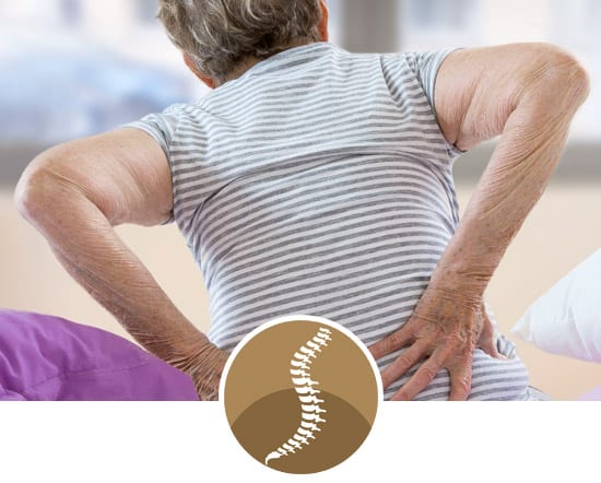 York Chiropractic Center | an older woman wearing a striped t-shirt holding her lower back in pain